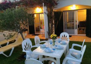 a white table and chairs in a yard at Casa Rosa Azul - Terracos de Benagil (Cliffside) in Benagil