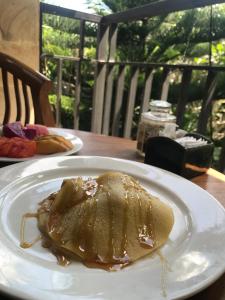 a piece of food on a white plate on a table at Arya Homestay in Ubud