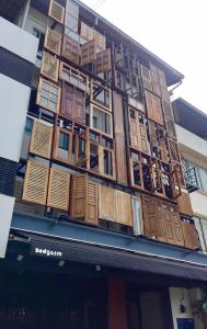 a building with wooden doors on the side of it at Bedgasm Hostel Chanthaburi in Chanthaburi