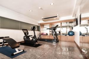 a gym with two exercise bikes and a treadmill at Samran Place Hotel in Bangkok