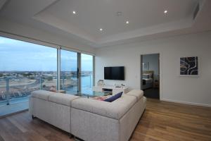 a living room with a couch and a large window at Wallaroo Marina Apartments in Wallaroo