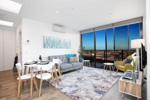 a living room with a couch and a table at StayCentral - Northcote Hill Penthouse in Melbourne