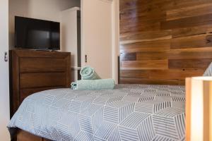a bedroom with a bed and a flat screen tv at Mudgee Apartments on Horatio Street in Mudgee