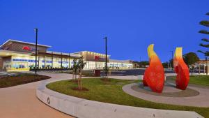 un centro commerciale con una grande scultura rossa e gialla di Bay Park Gardens 30 1 Warlters Street a Port Macquarie