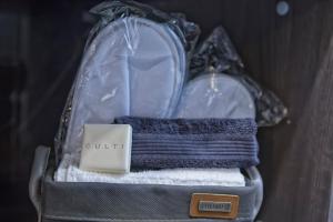 a bag filled with towels and a suitcase with a card at Suite Vogue Stazione in Voghera