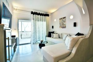 a white living room with a couch and a table at Santorini Loft in Kamari