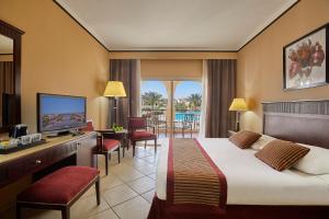 um quarto de hotel com uma cama e uma televisão em Jaz Mirabel Resort em Sharm El Sheikk