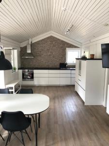 uma grande cozinha com uma mesa branca e cadeiras em Hällestrand Cottage -Sillen em Strömstad