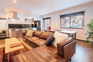 a living room with a couch and a table at Happo Apartments by Hakuba Hospitality Group in Hakuba