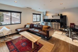 a living room with a leather couch and a table at Happo Apartments in Hakuba