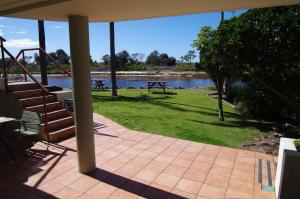 a patio with a view of a lake and a picnic table at Beachfront 5, 25 Willow Street in Crescent Head