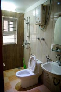 a bathroom with a toilet with the seat up and a sink at Sweet Dream Apartment in Kathmandu