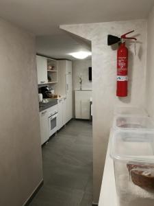 una cucina con estintore appeso al muro di B&B Giò a Napoli