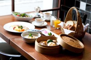 drewniany stół z talerzami żywności w obiekcie Rose Hotel Yokohama, The Distinctive Collection By WORLDHOTELS w mieście Jokohama