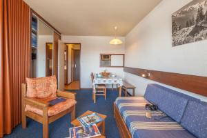 een woonkamer met een bank en een tafel bij Résidence Pierre & Vacances Les Mouflons I et II in Le Praz de Lys