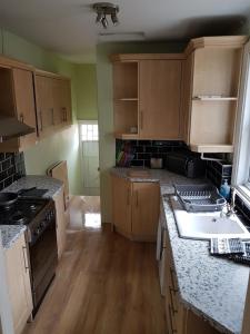 a kitchen with a sink and a stove top oven at Jesmond Vale 3 Bedroom Apartment in Newcastle upon Tyne