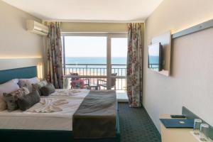 サニービーチにあるMPM Hotel Orel - Ultra All Inclusiveのベッドとバルコニー付きのホテルルーム
