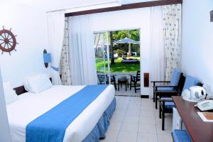pokój hotelowy z łóżkiem, stołem i krzesłami w obiekcie Voyager Beach Resort w mieście Mombasa