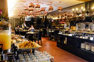 un ristorante con persone sedute ai tavoli con cibo di Horizon Hotel a Kota Kinabalu