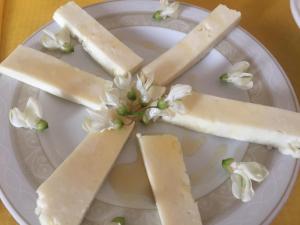 a plate with three pieces of cheese and flowers at Poggio Moretto in Manciano +27 photos