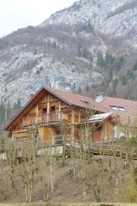 una gran casa de madera con una montaña en el fondo en Gite rural les Combes, en Thorens-Glières