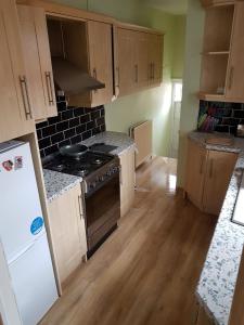 a kitchen with a stove and a white refrigerator at Jesmond Vale 3 Bedroom Apartment in Newcastle upon Tyne