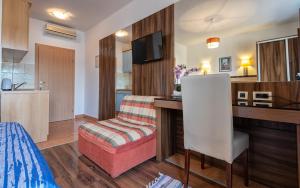 a room with a desk and a chair and a kitchen at Apartments Villa Kresic in Neum
