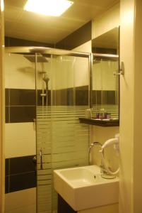 a bathroom with a sink and a shower and a mirror at Mini Hotel in İzmir