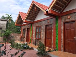 a house with wooden doors and a patio at Tam Coc Cozy Homestay in Ninh Binh