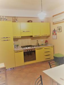 cocina amarilla con armarios amarillos y fogones en Apartment Grotte Furci Siculo en Furci Siculo