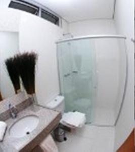 La salle de bains est pourvue de toilettes, d'un lavabo et d'une douche. dans l'établissement Hotel Conexão Pampulha, à Belo Horizonte