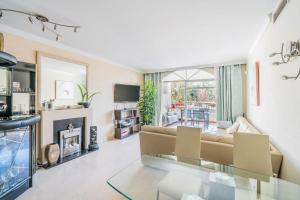a living room with a couch and a fireplace at Aloha Gardens Townhouse in Marbella