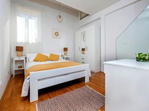 biała sypialnia z łóżkiem i dywanem w obiekcie Casa Dora w Rovinj