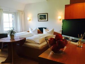 a hotel room with a bed and a bowl of fruit on a table at Hotel-Pension Seeadler in Prerow