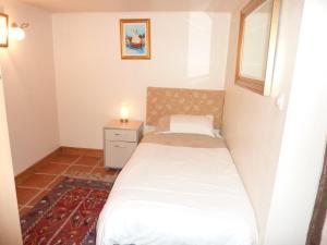 a small bedroom with a bed and a night stand at Lavender Cottage in Chézelles
