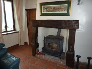 a living room with a wood stove in it at Lavender Cottage in Chézelles