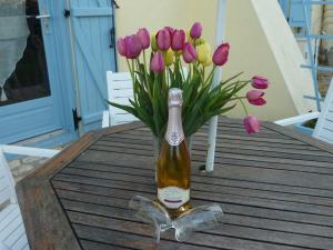 uma garrafa de champanhe sentada numa mesa com flores em Lavender Cottage em Chézelles