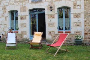 trois chaises assises dans l'herbe devant un bâtiment dans l'établissement Logis de la Pichonnière, à  Charcé-Saint-Ellier-sur-Aubance