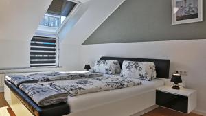 a bed in a white room with a window at Outlet Apartments Metzingen in Metzingen