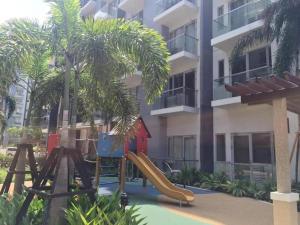 a playground in front of a building with a slide at One Palm Tree Villas in Manila