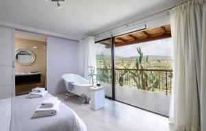 a bedroom with a bed and a tub and a large window at Villa Thea in Peyia +45 photos