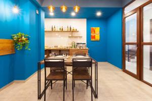 une salle à manger avec des murs bleus, une table et des chaises dans l'établissement Hotel Amser, à Tbilissi