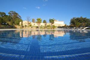 a swimming pool with blue tiles on the water at Pinheiros da Balaia Villas in Albufeira