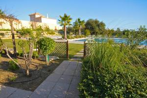 een tuin met een hek en een zwembad bij Pinheiros da Balaia Villas in Albufeira