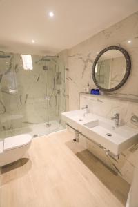 a bathroom with a sink and a shower and a toilet at Christchurch Harbour Hotel & Spa in Christchurch