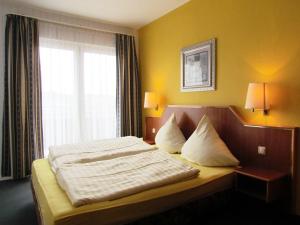 a bed in a hotel room with a window at Hotel Seeblick in Saalburg