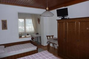 a bedroom with two beds and a tv on the wall at Haus Zwischenberger in Dölsach