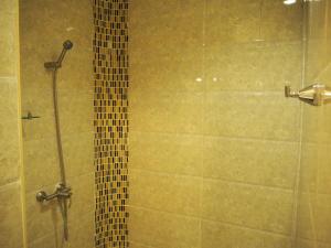 La salle de bains est pourvue d'une douche avec une porte en verre. dans l'établissement The Hotel Nakhonsawan, à Nakhon Sawan