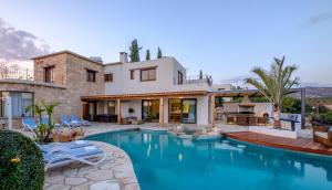 a house with a swimming pool in front of a house at Villa Palati in Peyia