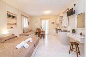 a living room with a bed and a kitchen at Myrtia Studios in Kionia